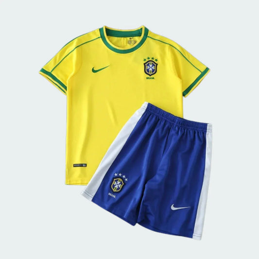 Kit infantil do Brasil com camisa amarela e shorts azul. Camisa com escudo do Brasil, 4 estrelas e logo Nike. Shorts azul com escudo do Brasil e logo Nike.