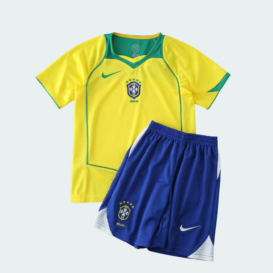 Kit infantil de futebol do Brasil, com camisa amarela e shorts azuis. Ambos possuem o escudo da seleção e o logo Nike.