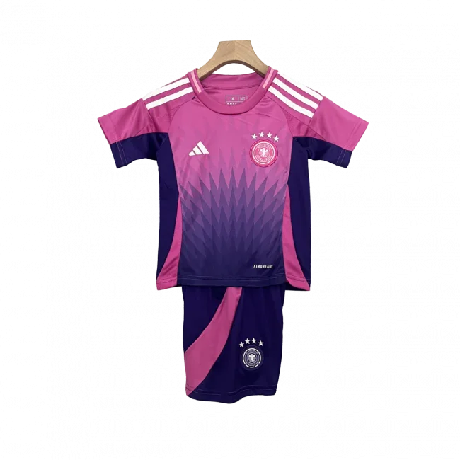 Kit de futebol infantil da Alemanha II 24/25. Camisa rosa e roxa com listras brancas e shorts roxos com detalhe rosa, ambos com o escudo da Alemanha.