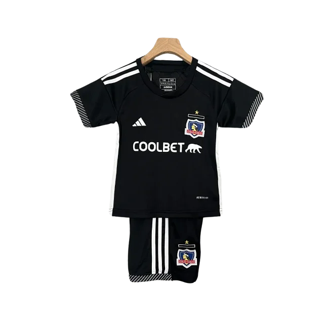 Kit infantil Colo Colo II 24/25 preto. Camisa preta com listras e logos brancos, escudo Colo Colo, e shorts pretos com listras brancas.