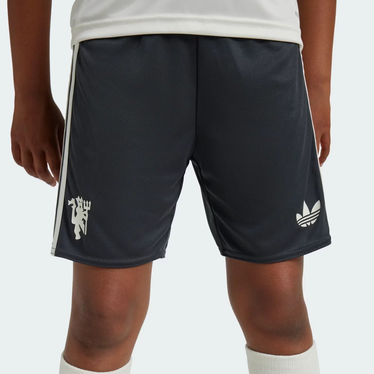Mini Mantos: Kit oficial infantil Manchester United. Shorts escuros com logos do time e Adidas, parte da camisa