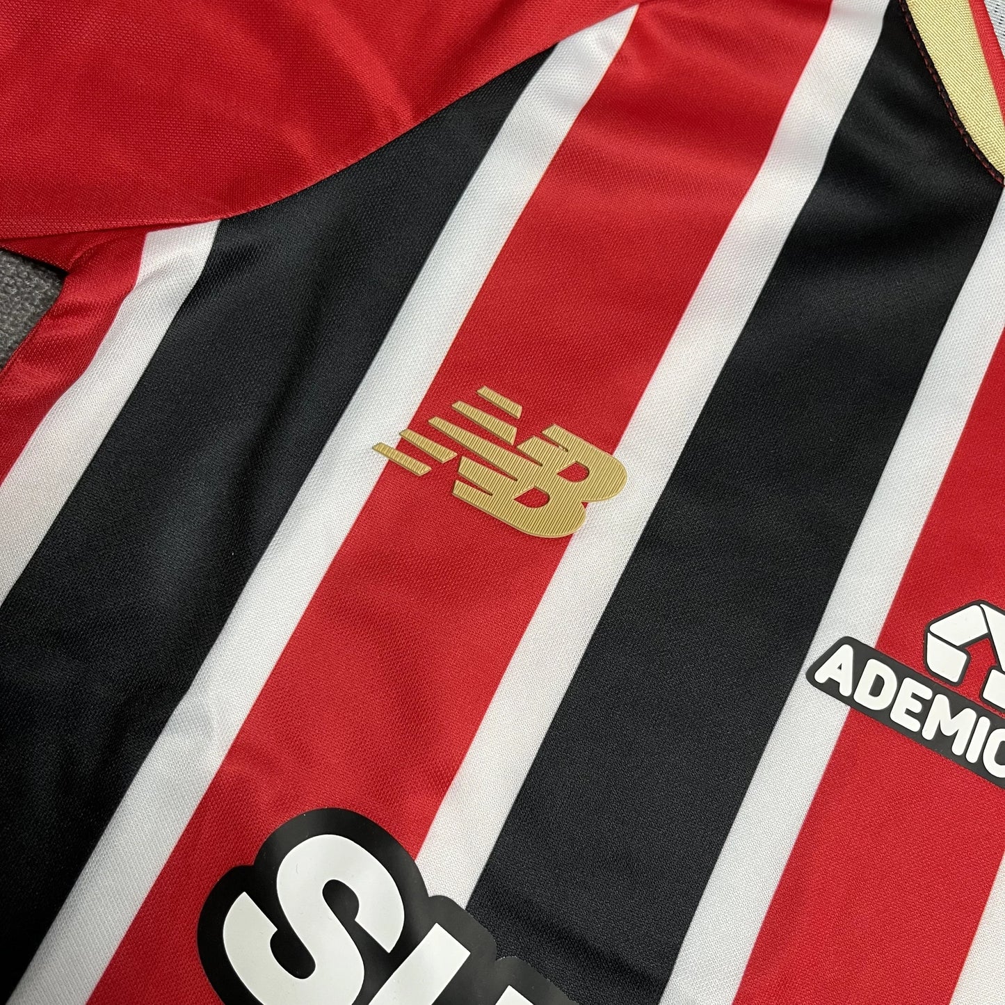 Camisa oficial kit Mini Mantos São Paulo FC infantil. Detalhe New Balance, listras vermelho, preto e branco