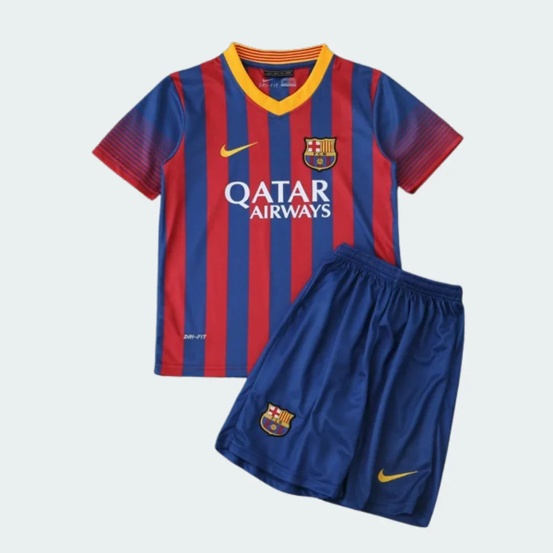 Kit infantil Barcelona 13/14, camisa listrada azul e vermelha com gola amarela, shorts azul, logos e escudos do clube visíveis.