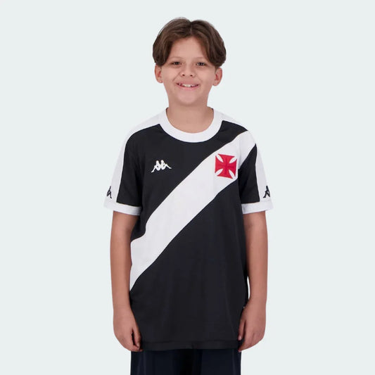 Foto de menino sorrindo, vestindo camisa de futebol infantil preta do Vasco com faixa diagonal branca, escudo e logo Kappa.