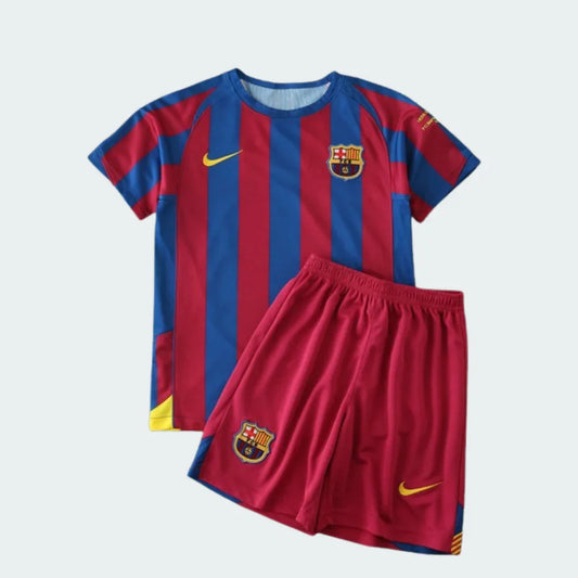 Kit infantil Barcelona 05/06 com camisa listrada azul e vermelha, escudo do Barcelona e logo Nike. Shorts vermelhos com escudo e logo Nike.