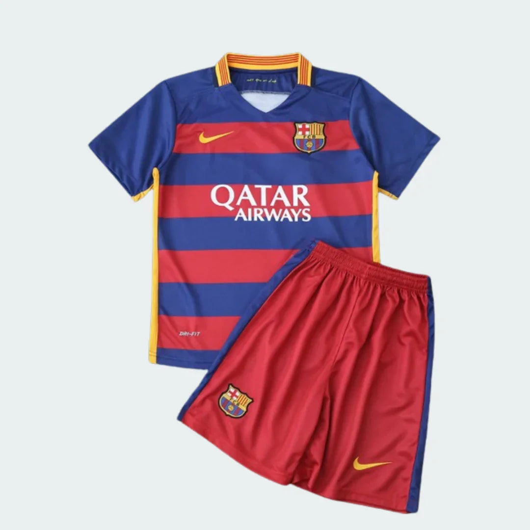 Kit infantil Barcelona 15/16. Camisa azul e vermelha listrada, shorts vermelhos. Escudos do clube e logo Nike em amarelo.