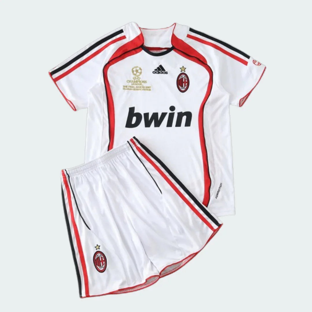 Kit infantil Milan 06/07 branco com detalhes vermelhos e pretos, logo Adidas, bwin, escudo do Milan e patch da Champions League.