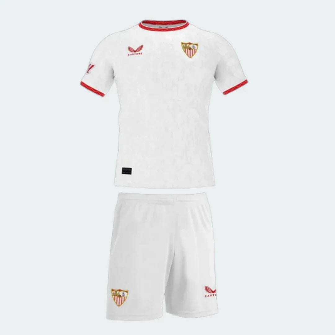 Kit infantil Sevilla 24/25 branco com camisa de manga curta e shorts. Gola e punhos em vermelho. Escudo do Sevilla e logo Castore.