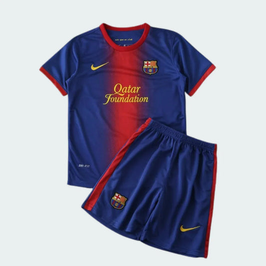 Kit infantil Barcelona 12/13 azul e vermelho. Camisa e shorts. Escudos do Barcelona, patrocínio Qatar Foundation e logos Nike.