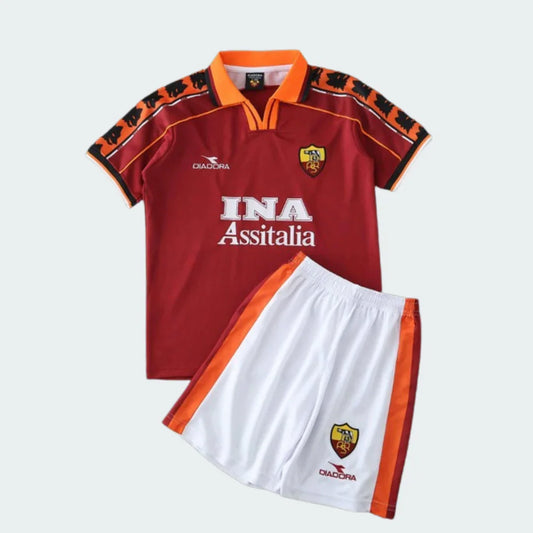 Kit infantil retrô da Roma com camisa grená, gola laranja e calção branco com listras laterais.