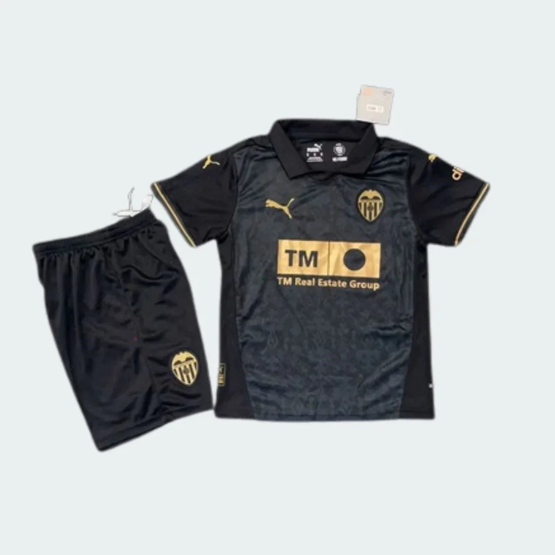 Kit infantil Valencia II 24/25 preto e dourado. Camisa preta com gola polo, logo Puma, escudo Valencia e patrocínio TM dourados. Short preto.