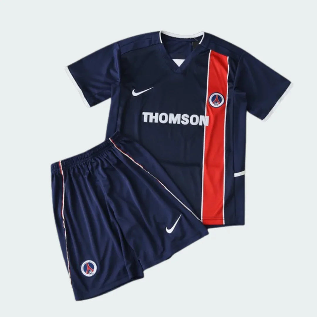 Kit infantil completo PSG retrô 02/03 azul marinho: camisa com faixa vermelha, logo Nike e Thomson, shorts com logo Nike e escudo.