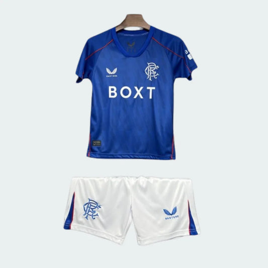 Kit infantil do Rangers, camisa azul com detalhes em vermelho, patrocínio BOXT e escudo do clube, e shorts brancos com escudo.