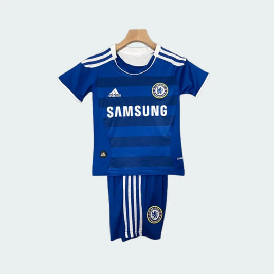 Kit infantil de futebol do Chelsea, camisa e shorts azuis com detalhes brancos e logo Samsung, pendurado em cabide.