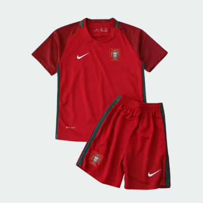 Kit infantil de futebol de Portugal, camisa e shorts vermelhos com detalhes verdes, escudo de Portugal e logos Nike brancos.