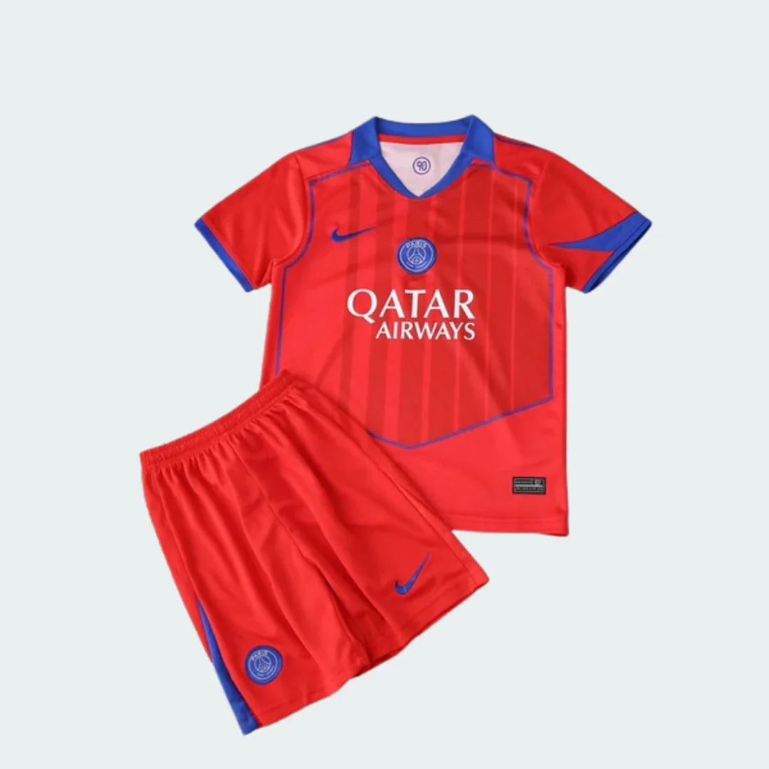 Kit infantil de futebol composto por camisa e shorts, predominantemente vermelhos com detalhes azuis. A camisa possui escudo e logo Nike.