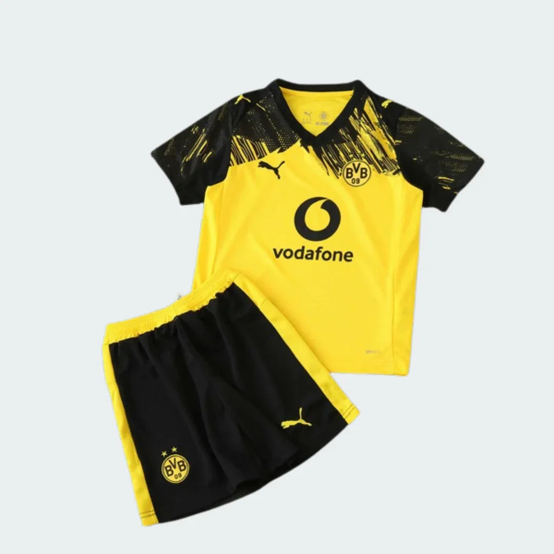 Kit infantil do Borussia Dortmund com camisa amarela, detalhes pretos nos ombros e calção preto com faixas amarelas.