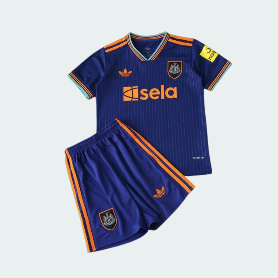 Kit infantil Newcastle azul escuro com detalhes laranja e verde água. Camisa e shorts com escudo, logo Adidas e patrocinadores Sela e noon.