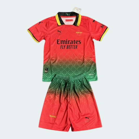 Kit infantil do Milan com camisa e shorts em gradiente vermelho e verde. A camisa tem gola preta e amarela e logos Puma e Emirates.