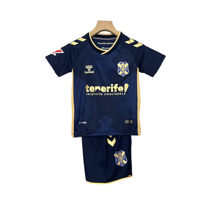 Kit infantil Tenerife II 24/25, camisa e shorts azul-marinho com detalhes amarelos, logo Hummel e escudo do Tenerife, em fundo preto.
