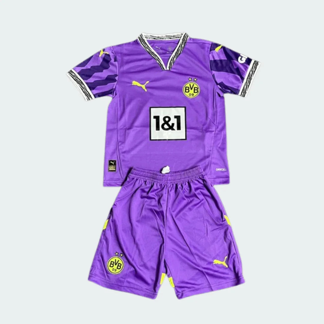 Kit de futebol infantil do Borussia Dortmund de goleiro 25/26 roxo com detalhes amarelos, incluindo camisa e shorts. Logos Puma e BVB visíveis.