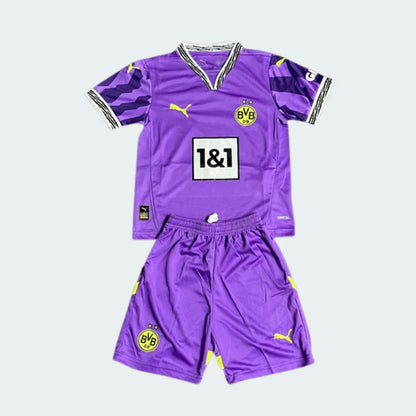 Kit de futebol infantil do Borussia Dortmund de goleiro 25/26 roxo com detalhes amarelos, incluindo camisa e shorts. Logos Puma e BVB visíveis.