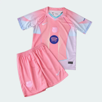 Kit infantil completo Barcelona 25/26 rosa. Camisa rosa com detalhes brancos/azuis, escudo Barcelona e logo Spotify. Shorts rosa com escudo.