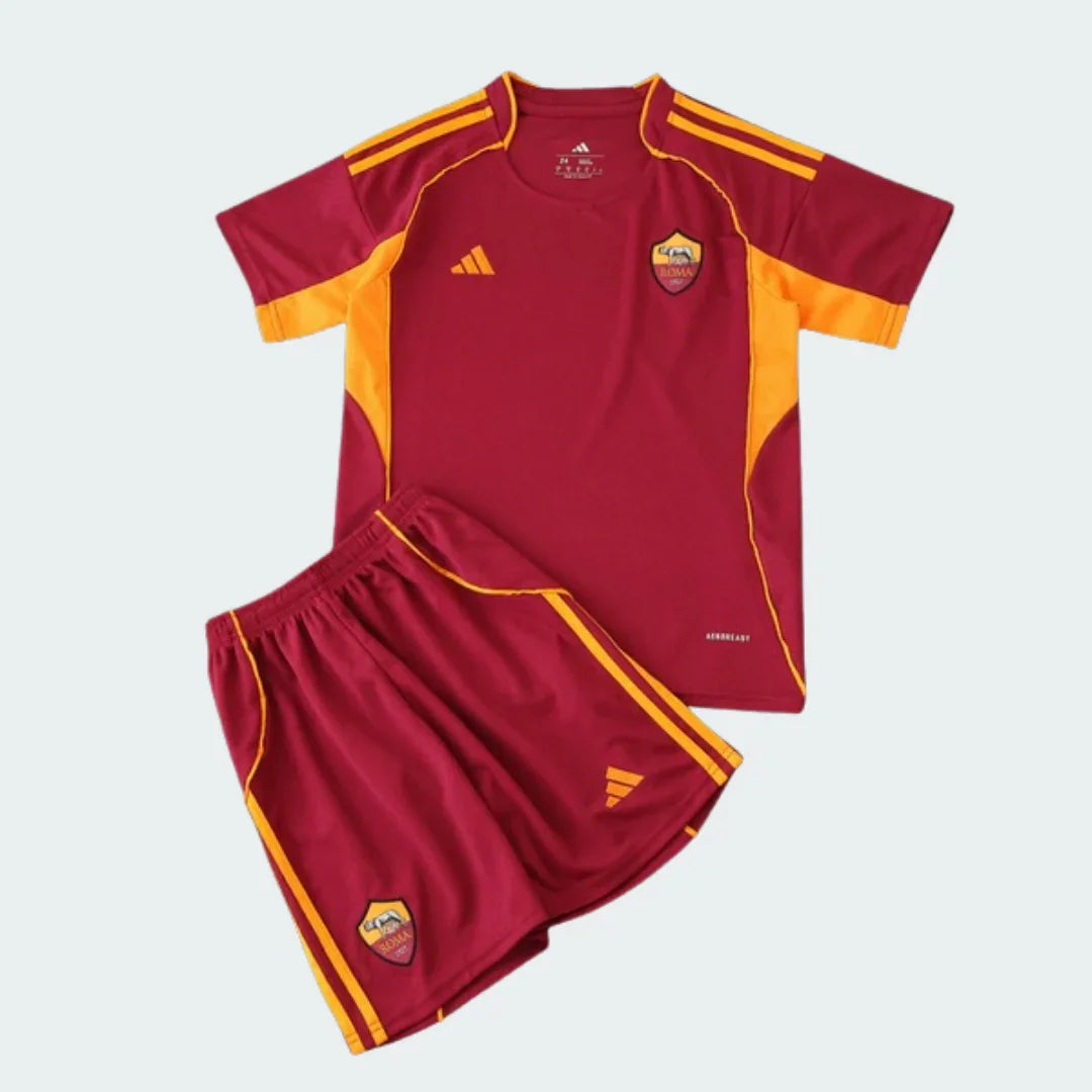 Kit infantil completo da Roma na cor vermelho escuro com detalhes laranja, incluindo camisa com escudo da Roma e shorts com logo Adidas.