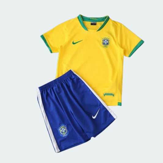 Kit infantil retrô da Seleção Brasileira 2006 com camisa amarela e shorts azul. Detalhes verdes e brancos.