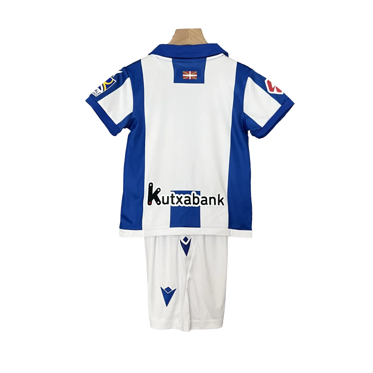 Kit oficial infantil Mini Mantos Real Sociedad Macron. Camisa e shorts azuis e brancos