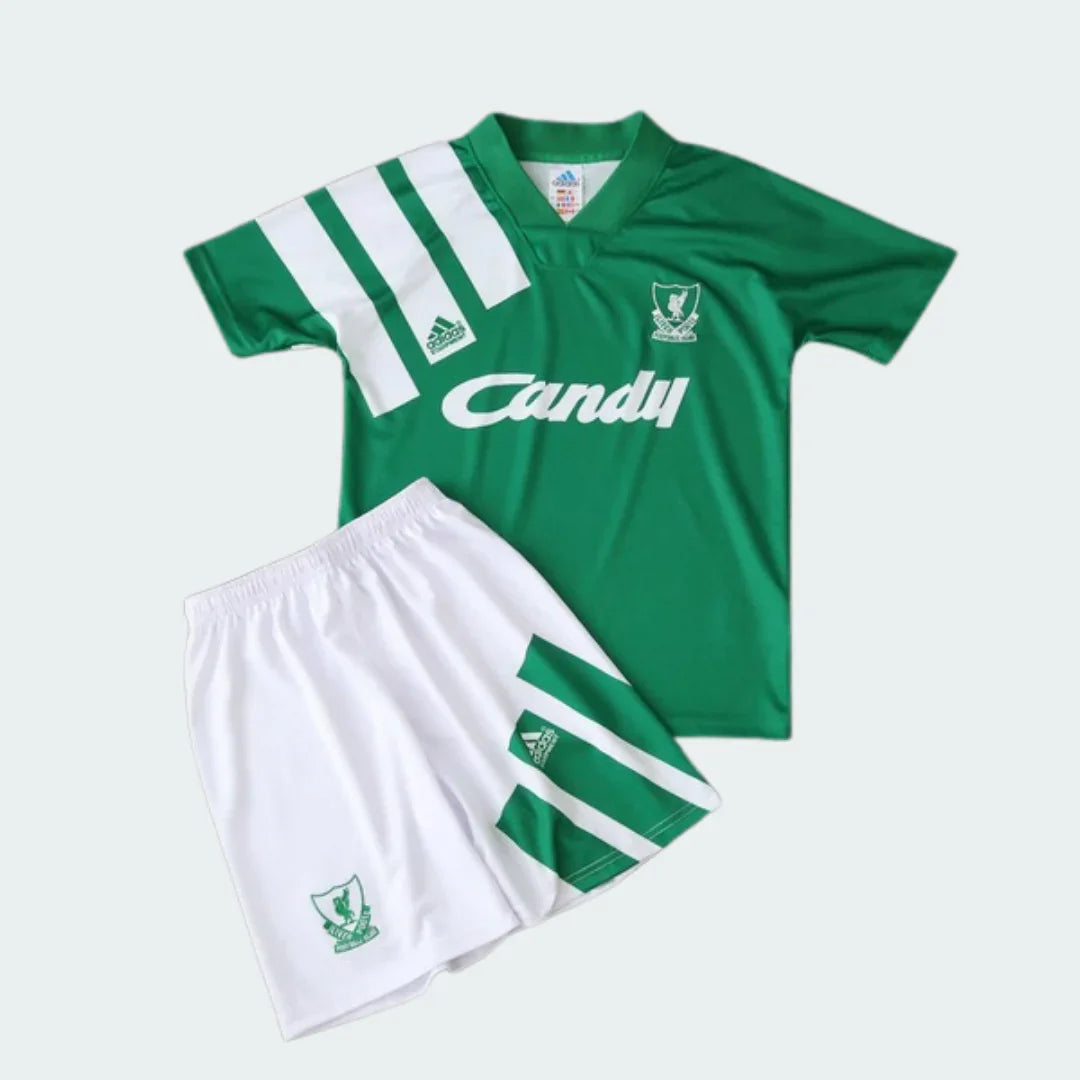 Foto de kit infantil Liverpool 1992. Camisa verde com listras brancas, escudo branco Liverpool, logo Adidas branco e 'Candy' branco. Short branco com listras verdes, escudo verde Liverpool e logo Adidas verde.