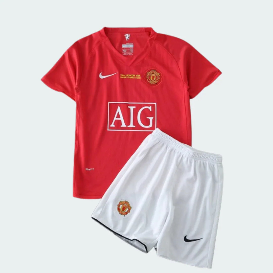 Kit infantil Manchester United retro 07/08, camisa vermelha com AIG, escudo e Nike, shorts branco com escudo e Nike.