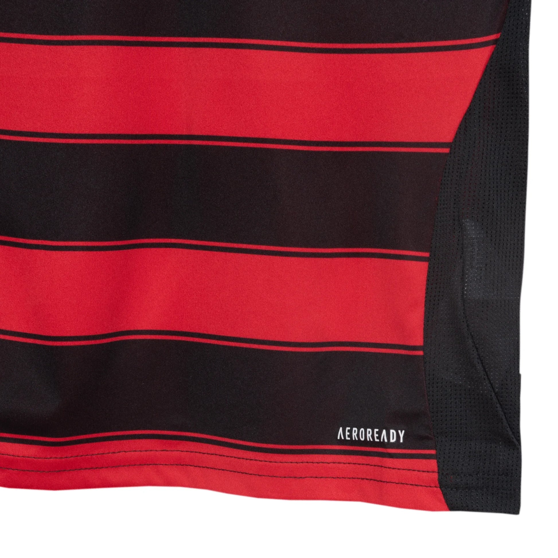 Close-up de camisa infantil com listras horizontais pretas e vermelhas, detalhe de malha preta na lateral e logo AEROREADY.