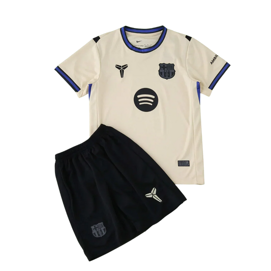 Kit infantil completo do FC Barcelona, camisa off-white/bege com escudo, logo Spotify e Nike, além de shorts pretos.