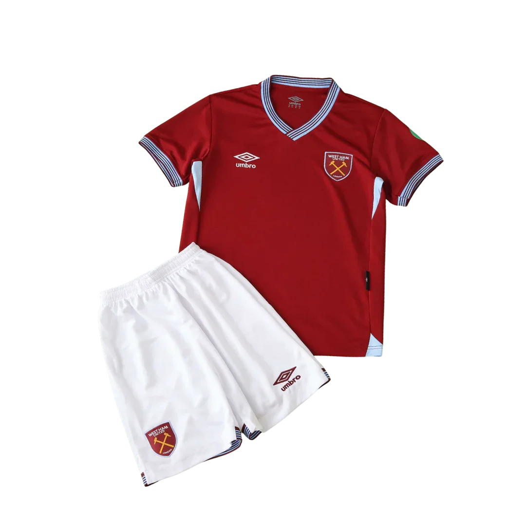 Kit infantil West Ham I 25/26, camisa vermelha bordô e shorts brancos com escudo West Ham e logo Umbro, fundo preto.