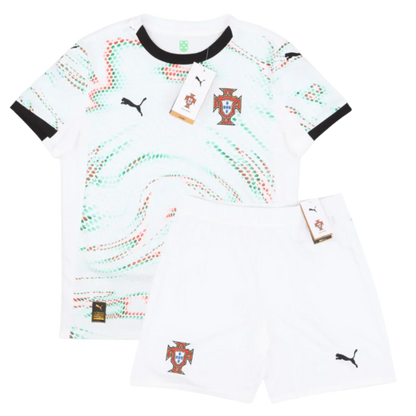 Kit infantil Portugal 25/26, camisa branca com estampa de pontos vermelhos e verdes, shorts brancos. Escudo de Portugal e logo Puma.