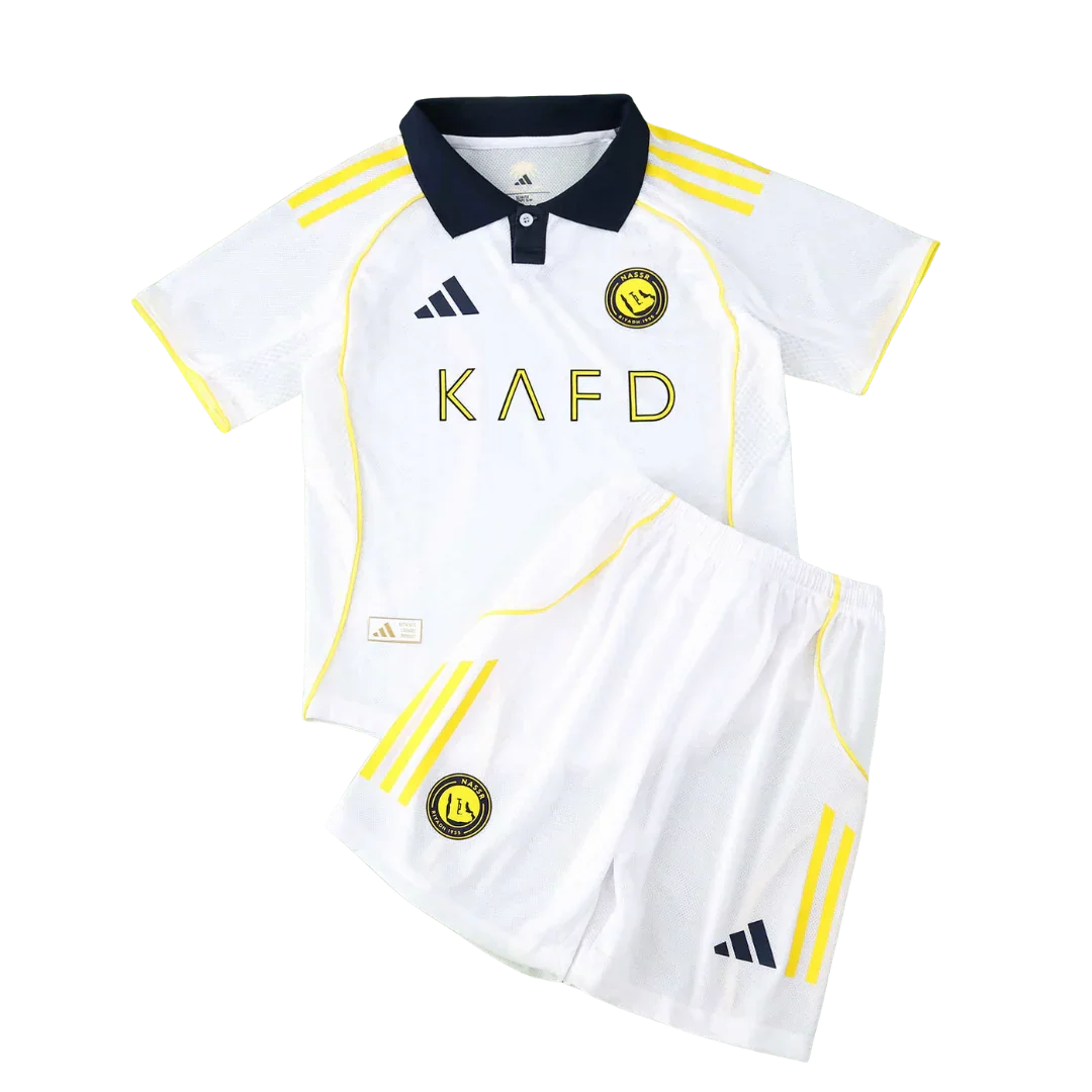 Kit infantil Al Nassr branco com gola azul marinho, listras e logos amarelos, shorts brancos com faixas amarelas.