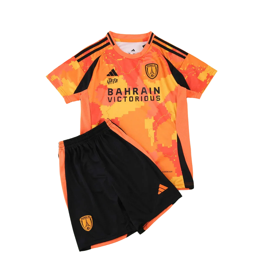 Kit infantil Paris FC 25/26 com camisa laranja pixelada e shorts pretos. Detalhes em preto e laranja. Escudos do time e patrocinadores visíveis.