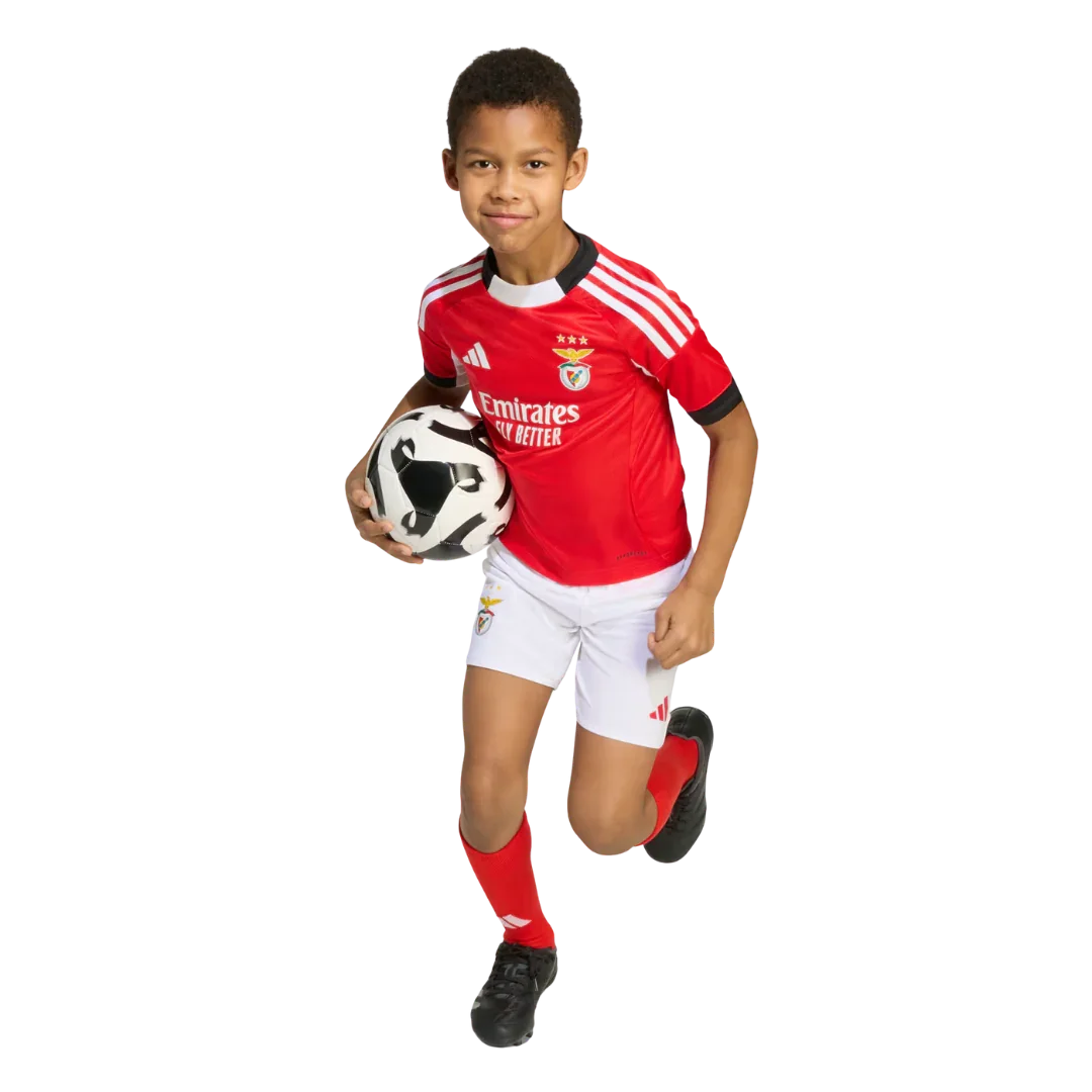 Mini Mantos oficial Benfica infantil. Criança feliz com kit camisa, shorts e meias, segurando bola