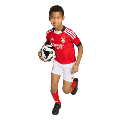 Mini Mantos oficial Benfica infantil. Criança feliz com kit camisa, shorts e meias, segurando bola
