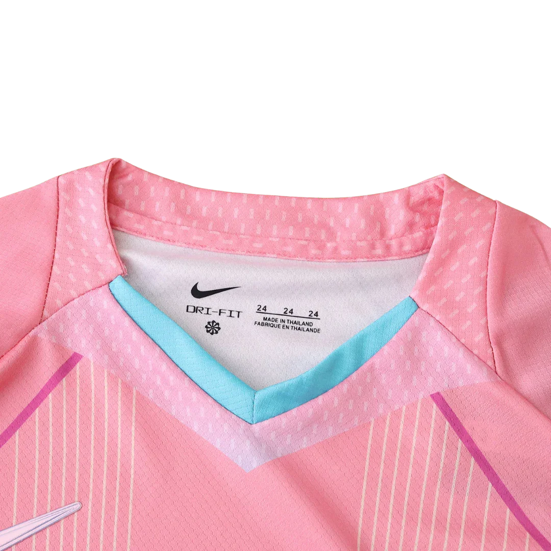 Vista interna da gola de uma camisa de futebol infantil rosa com detalhes azuis. Possui logo Nike, DRI-FIT e tamanho 24.