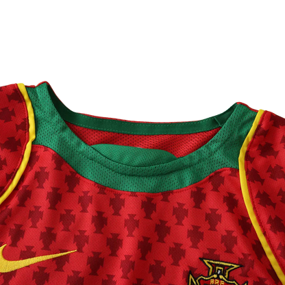Camisa oficial infantil Portugal Mini Mantos kit. Gola verde, padrão de cruzes, logo Nike e FPF