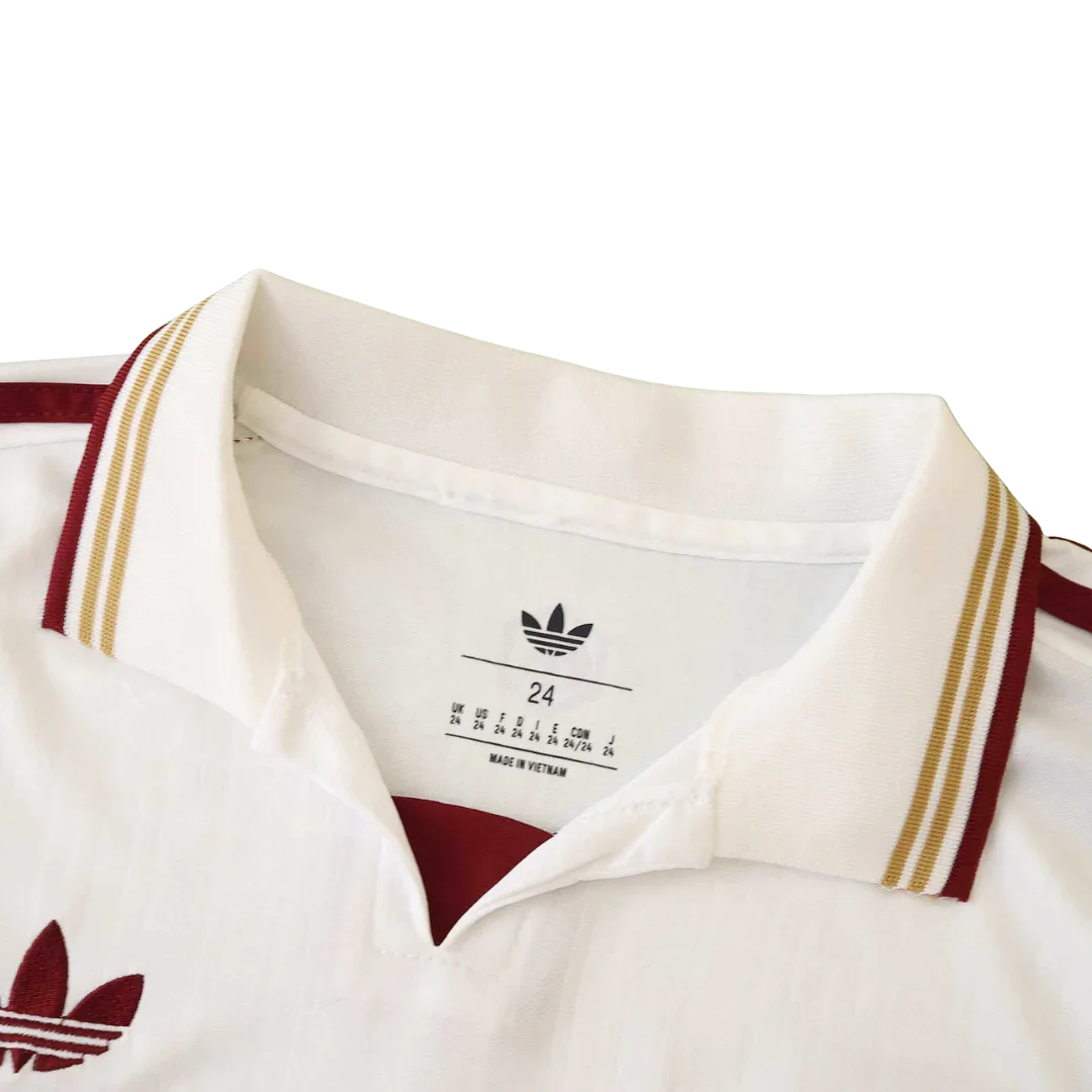 Close-up da gola de camisa infantil Adidas branca com detalhes em bordô e dourado. Rótulo interno com tamanho 24 e 'Made in Vietnam'.