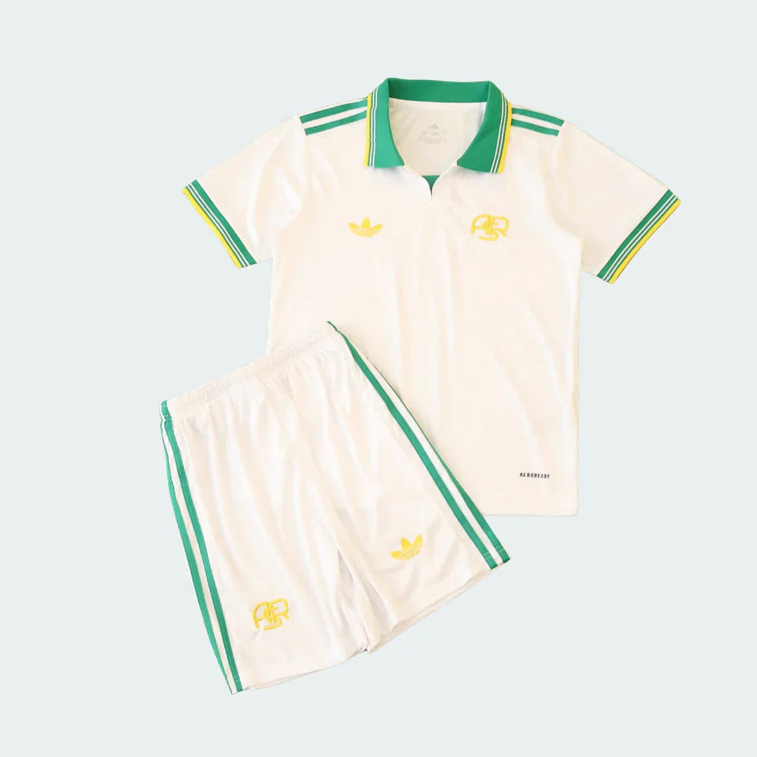Kit infantil Roma III 25/26 com camisa branca polo e shorts brancos, ambos com listras verdes e amarelas, e logos amarelos.