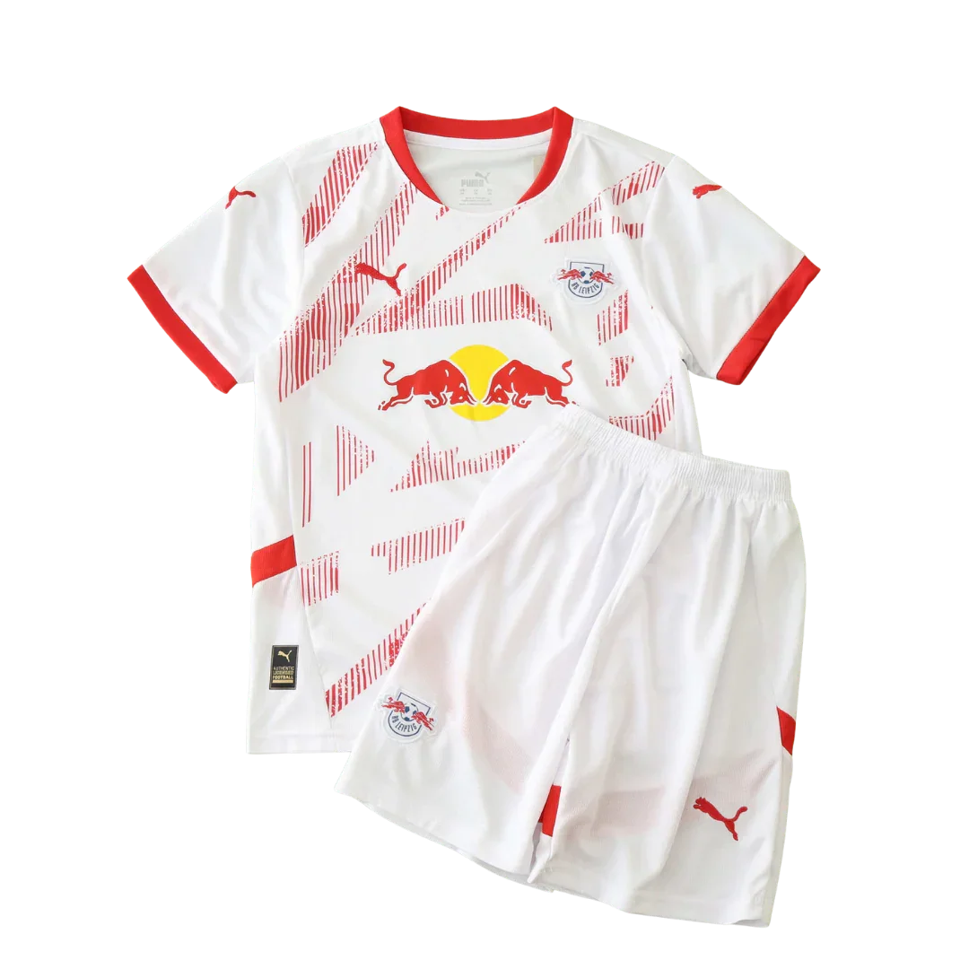 Kit de futebol infantil Leipzig 24/25 branco com detalhes e listras vermelhas, escudo do time e logo Puma visíveis na camisa e shorts.