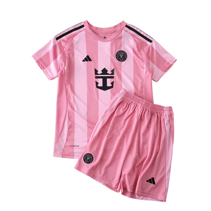 Kit de futebol infantil Inter Miami I 24/25 com camisa e shorts rosa, listras claras, escudos e logos Adidas pretos.