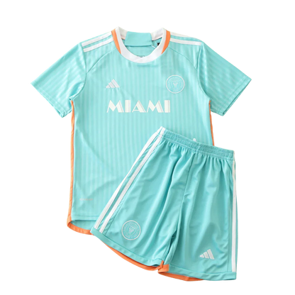 Kit infantil Inter Miami 24/25, camisa e shorts azul-claro com detalhes laranja e brancos, logos Adidas e escudo do time.
