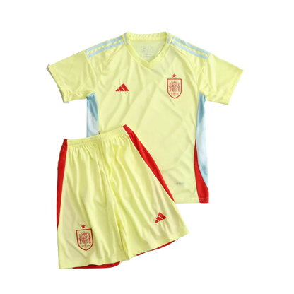 Kit infantil da Espanha II 24/25. Camisa e shorts amarelo claro com detalhes em vermelho, escudo da Espanha e logos Adidas.