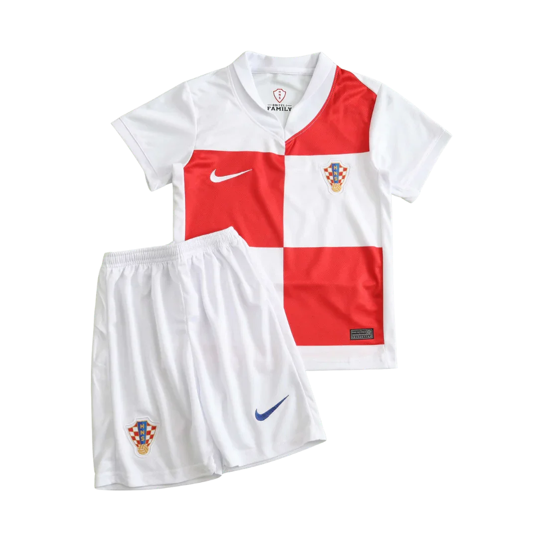 Kit infantil da Croácia, camisa xadrez branca e vermelha, shorts branco. Escudos da Croácia e logos Nike visíveis.