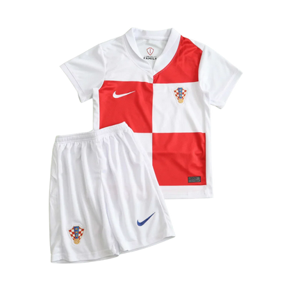 Kit infantil da Croácia, camisa xadrez branca e vermelha, shorts branco. Escudos da Croácia e logos Nike visíveis.